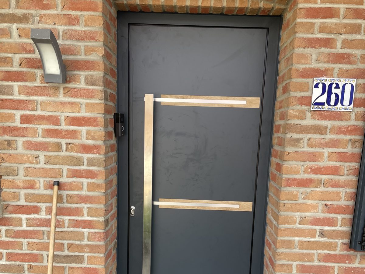Porte d'entrée posée dans un mur en brique